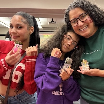 Three people display their temporary Temple "T" tattoos.