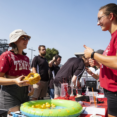 A woman talks to a facilitator at an outdoor event.