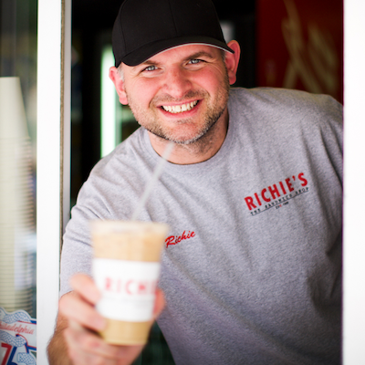 A man holding an iced coffee cup.